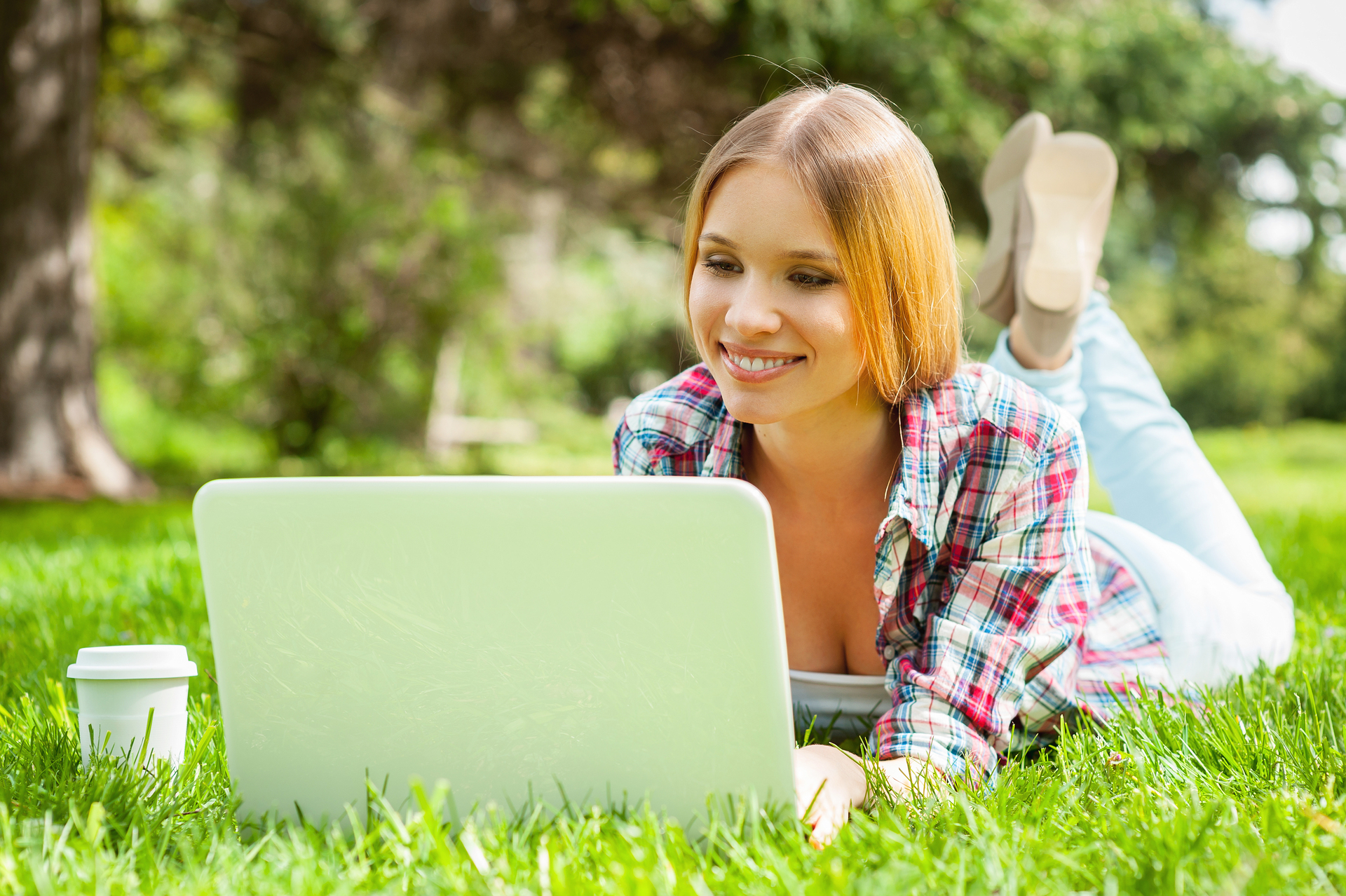 Studentka Uniwersytetu Łódzkiego na trawie z laptopem, korzystająca z platformy USOS UŁ